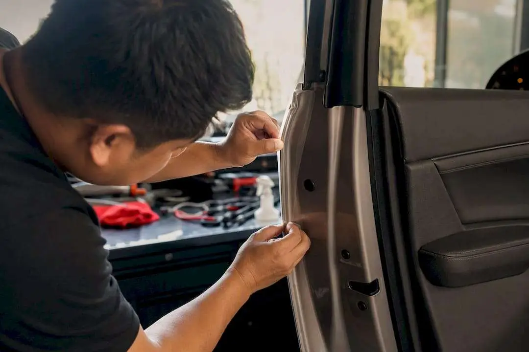 Close-up of hand applying clear door edge protection film