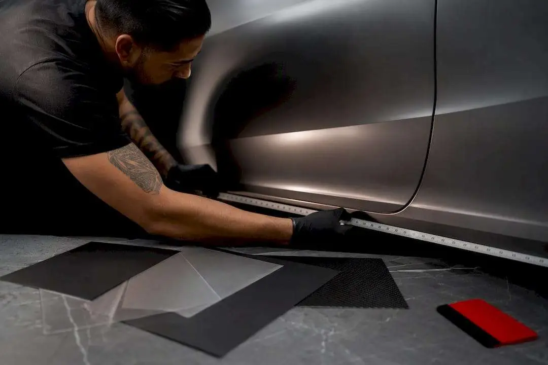 Technician measuring an anonymous vehicle panel