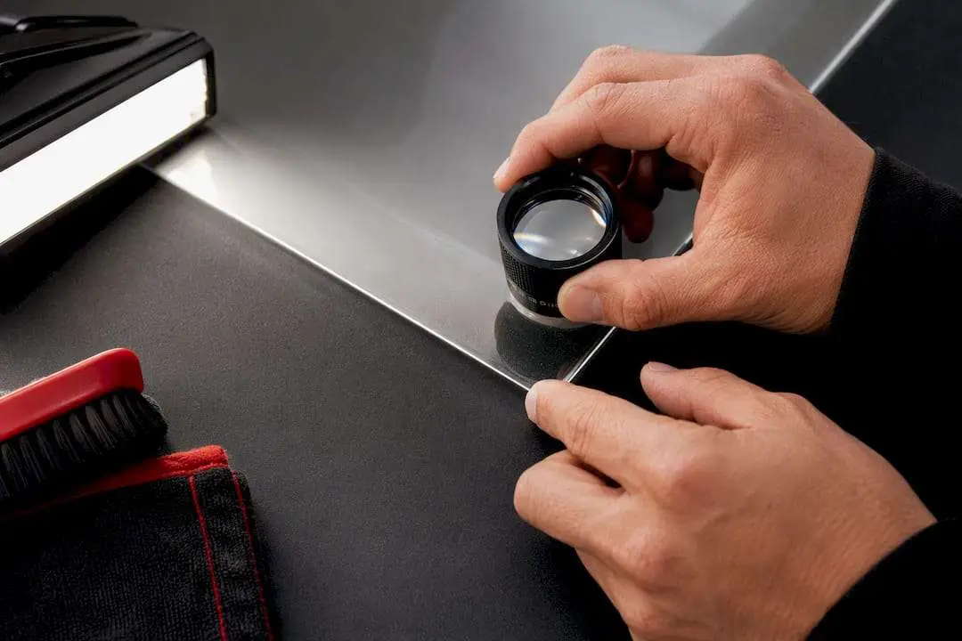Inspector examining PPF edge with magnifier