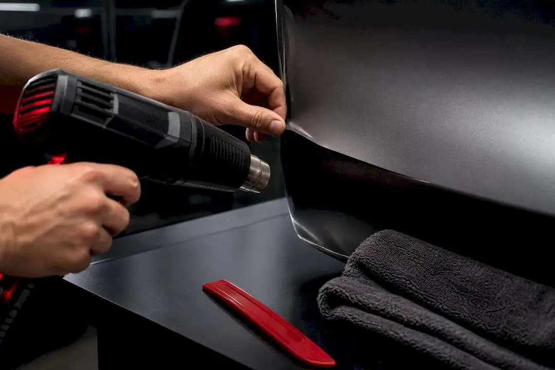Technician gently reheating lifted vinyl edge