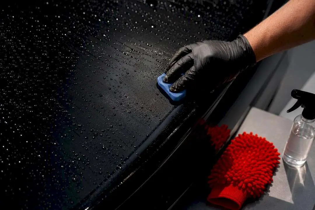 Technician decontaminating a vehicle paint panel