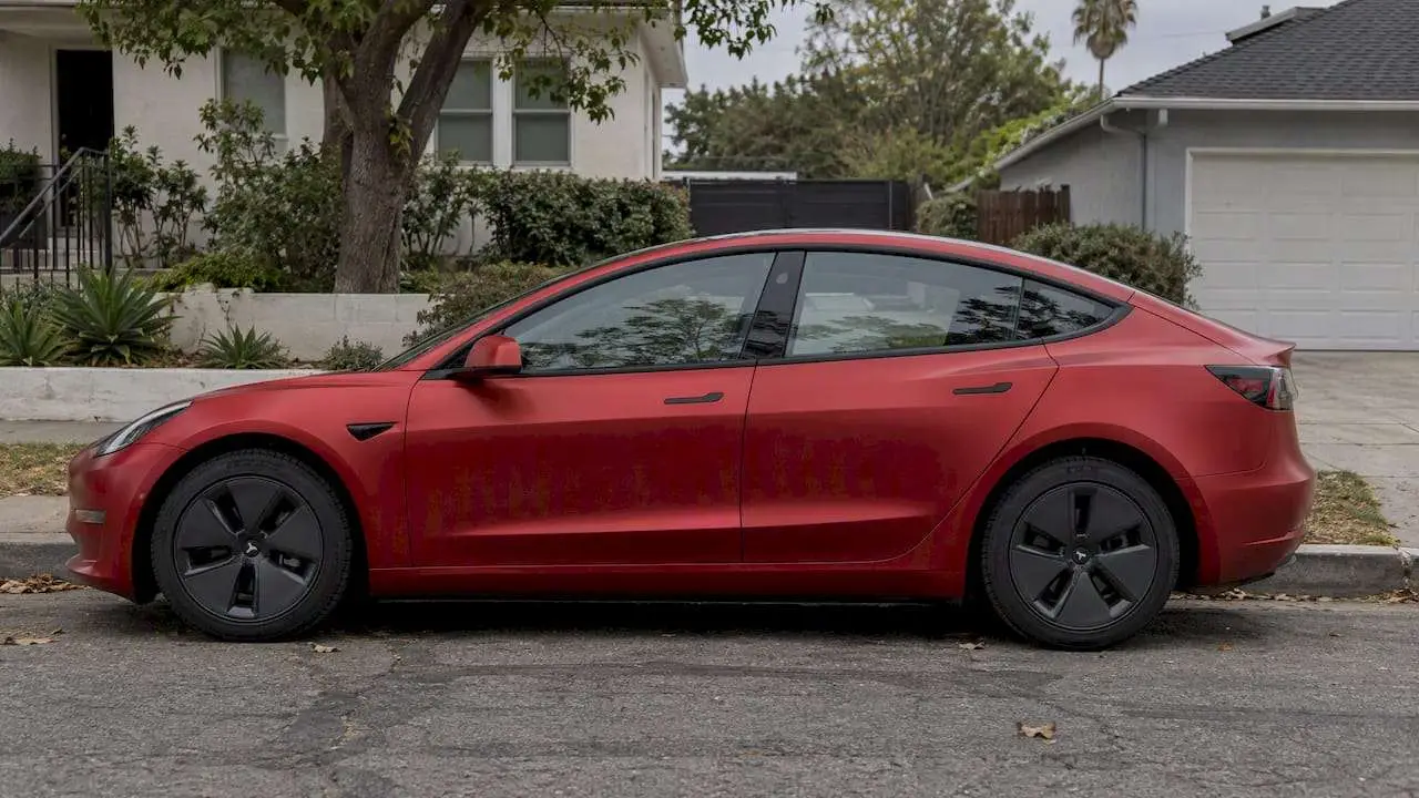 Satin-red Tesla parked on residential street