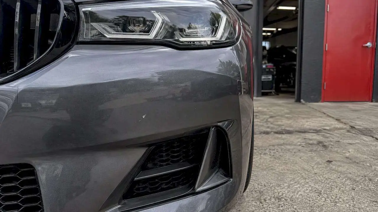 Rock chip visible on a wrapped car bumper
